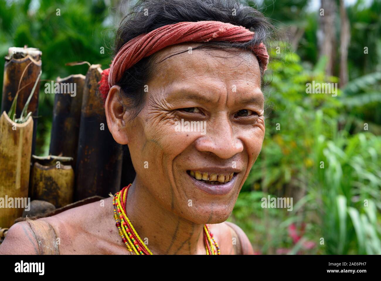 Muara Siberut, Mentawai Islands, Indonesia, 5 NOVEMBER 2019: Portrait  tribal men with traditional tattoos coming back from the jungle. He is carrying Stock Photo
