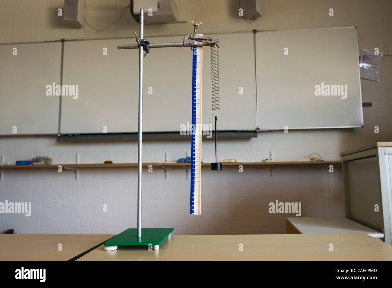 Experiment with mounting of a spring and weight. Demonstration of Hooke's law. Stock Photo