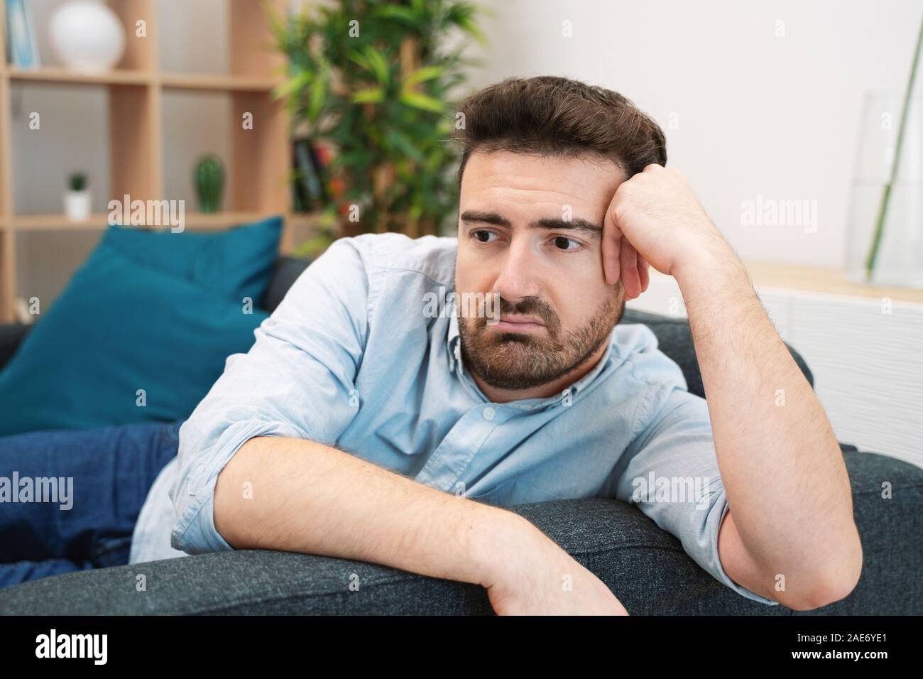 Sad man portrait at home feeling depressed Stock Photo - Alamy
