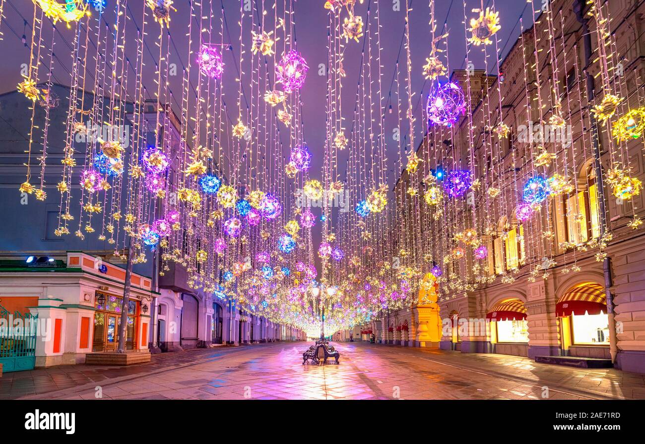 Moscow, Russia. Golden colorful rain of Christmas decorations hanging from the sky, on Nikolskaya street next to GUM in the capital. Beautiful lights. Stock Photo