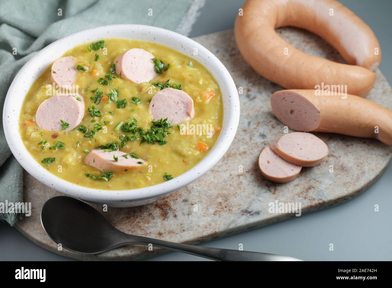 Dutch pea soup Snert with smoked sausage Rookworst on a rustic table Stock Photo