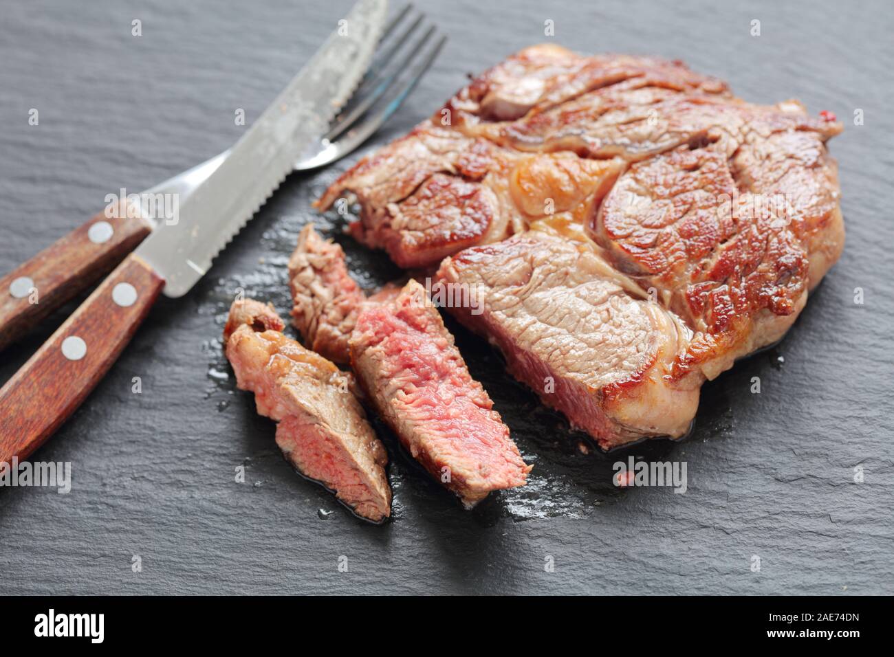 Sliced medium rare beef steak on a slate tray closeup Stock Photo