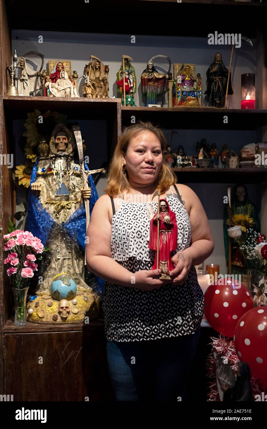 Posed photo of a devotee of a Santa Muerte in her home temple in Elmhurst, Queens, New York City. Stock Photo
