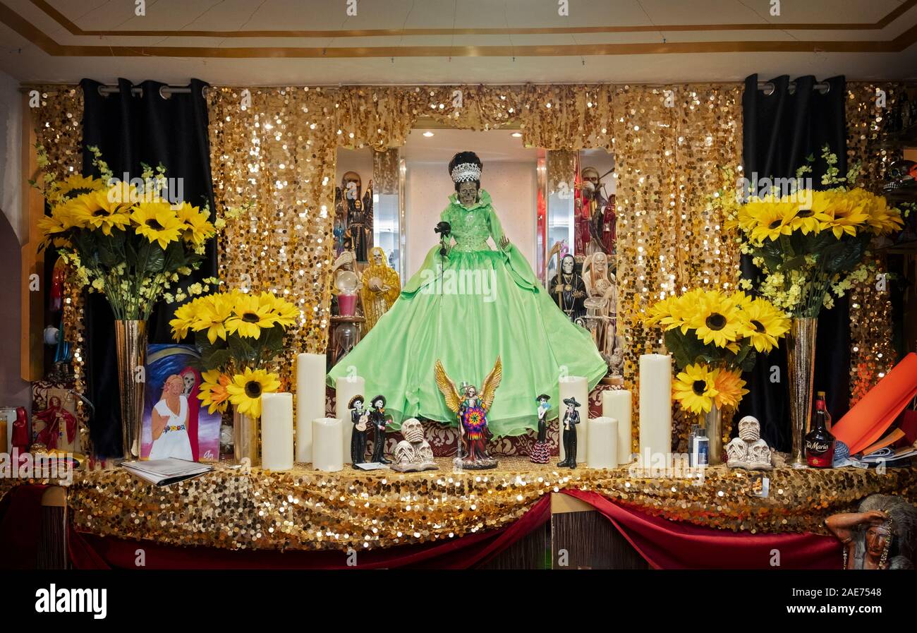 A Santa Muerte altar with statues & flowers in the home temple of a Mexican American devotee in Jackson Heights, Queens, New York City Stock Photo