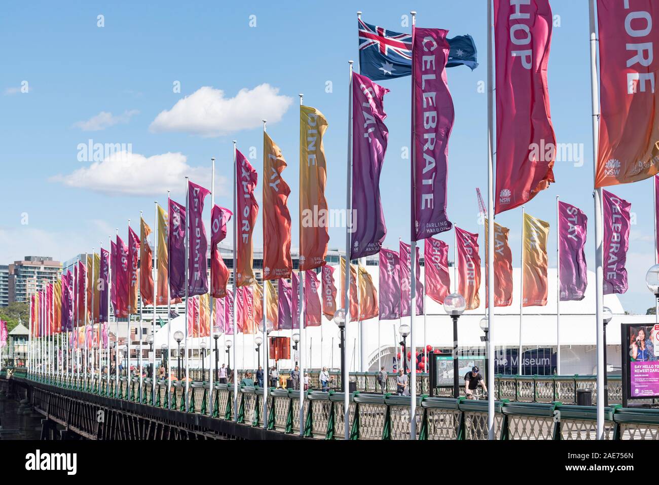 Multi coloured banner flags flutter in a strong morning wind blowing across the historic Pyrmont Bridge at Sydney's Darling Harbour precinct Stock Photo