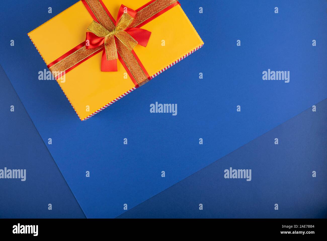 Box with gifts on a classic blue background. Christmas, New Year and Birthday concept. Top view, copy space for your text. Stock Photo