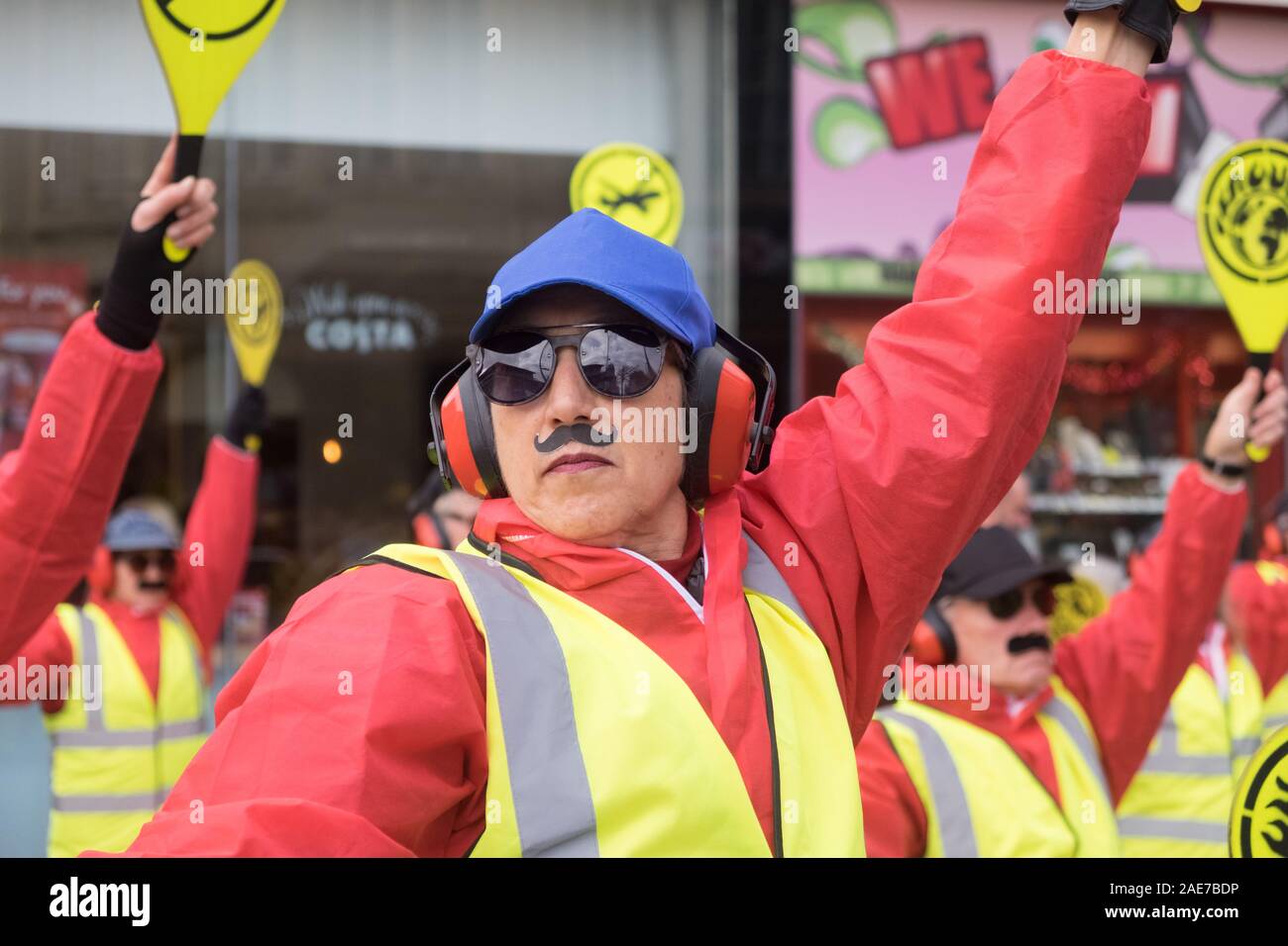 Weston-super-Mare, Somerset, UK, 7th December 2019. The Extinction Rebellion group stage a protest in the town to protest the planned Bristol Airport expansion. Dressed as runway directors with bats and false moustaches the group made a silent protest on the High Street. Local activists are concerned about the ecological impact of the expansion plans for Bristol Airport. Credit: Mr Standfast/Alamy Live News Stock Photo