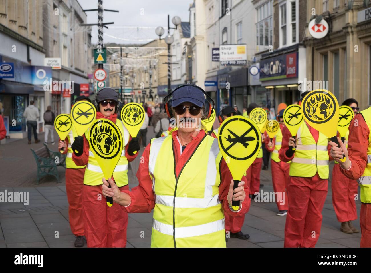 Weston-super-Mare, Somerset, UK, 7th December 2019. The Extinction Rebellion group stage a protest in the town to protest the planned Bristol Airport expansion. Dressed as runway directors with bats and false moustaches the group made a silent protest on the High Street. Local activists are concerned about the ecological impact of the expansion plans for Bristol Airport. Credit: Mr Standfast/Alamy Live News Stock Photo
