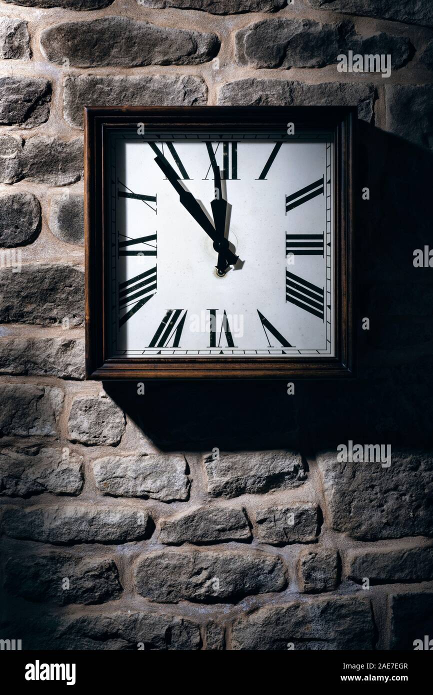 Square clock hanging on a stone wall Stock Photo Alamy