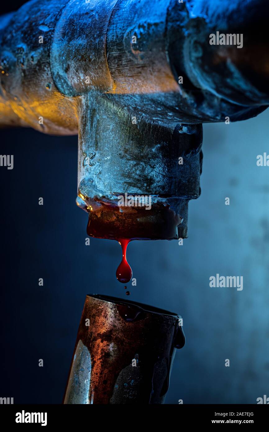 Blood dripping from a broken copper pipe. Stock Photo
