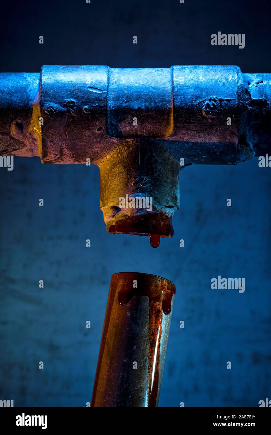 Blood dripping from a broken copper pipe. Stock Photo