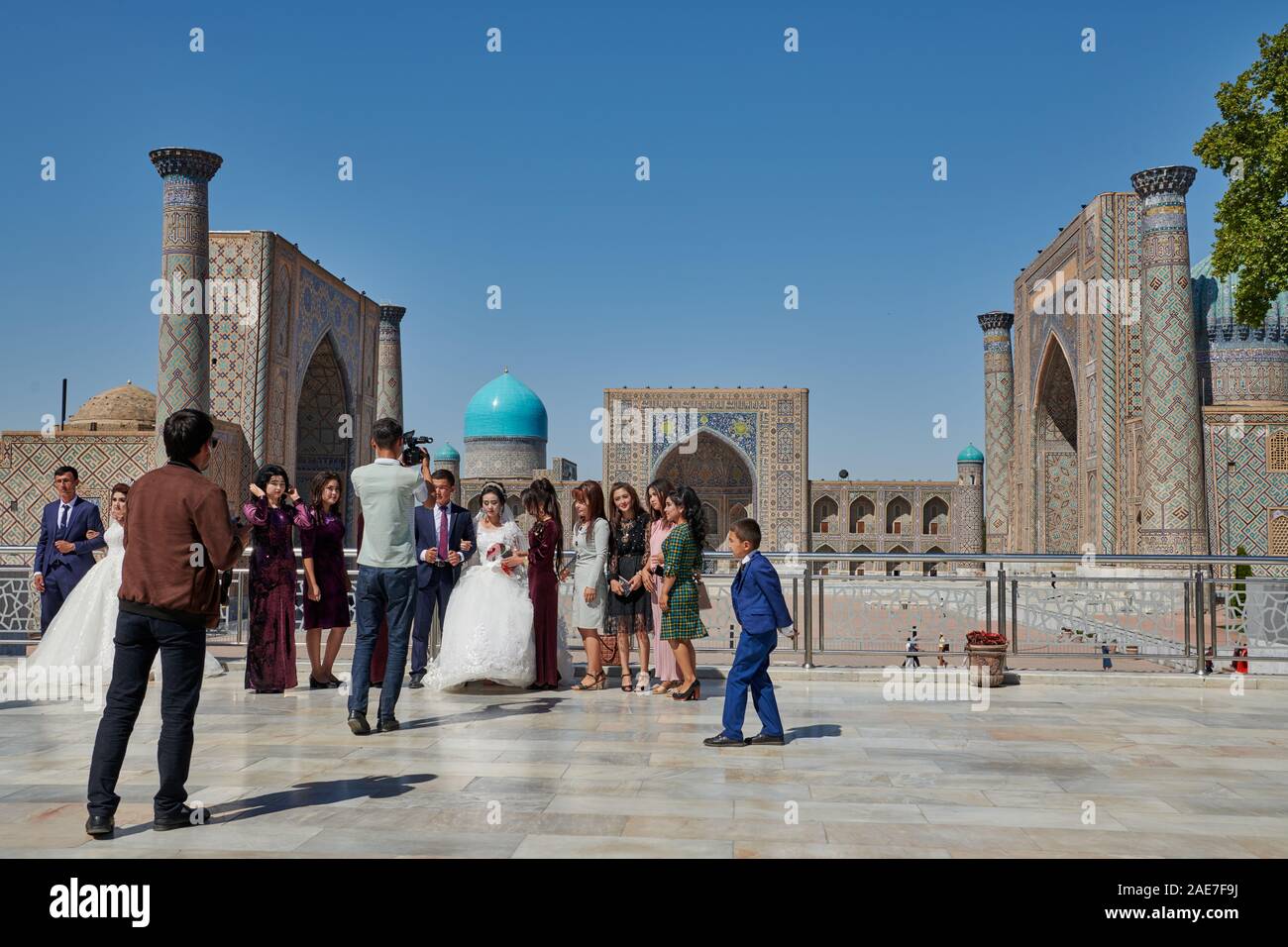 wedding party posing in front of famous Registan Square, Samarkand, Uzbekistan, Central Asia Stock Photo
