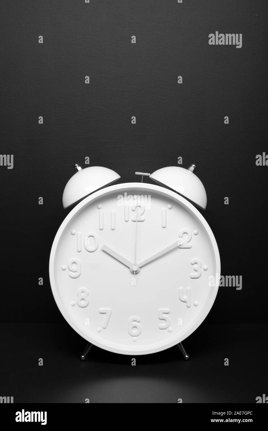 White retro alarm clock isolated on black background. Time concept