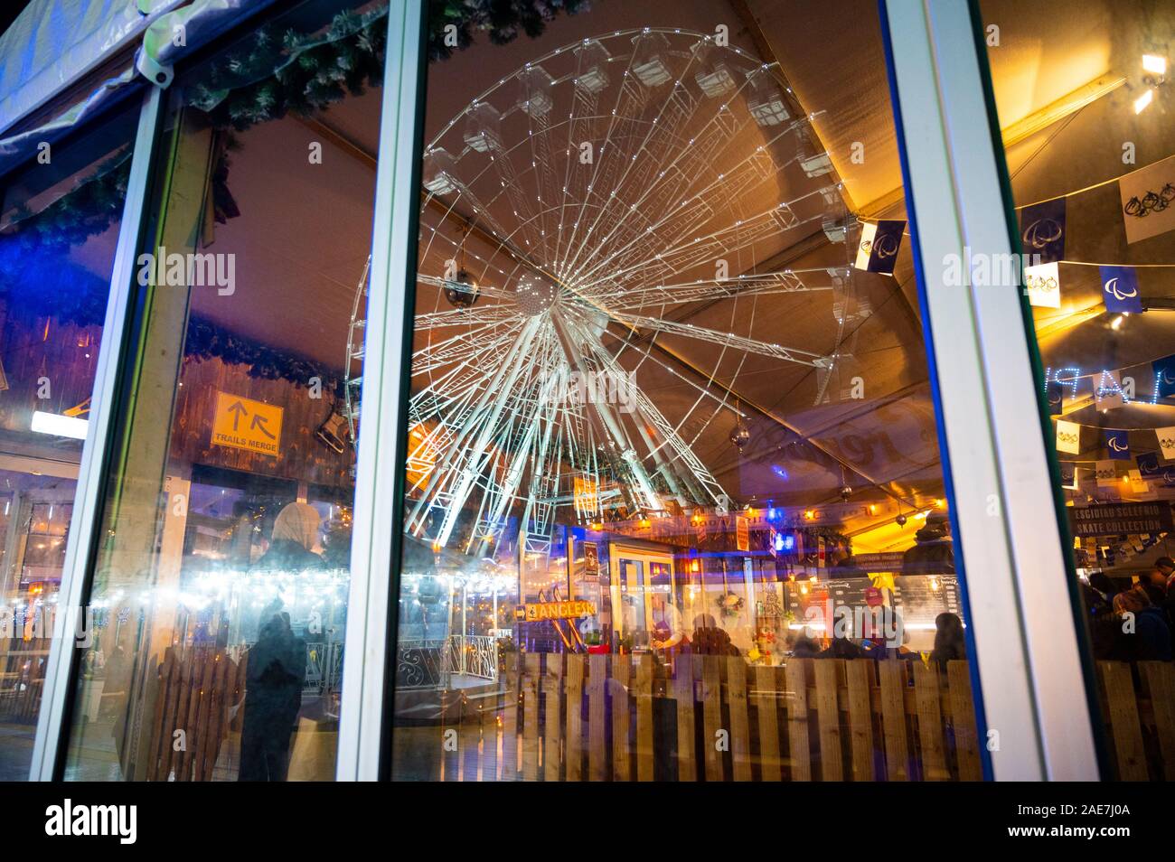 A Cold December night in Cardiff in the lead up to Christmas. Colourful reflections in a window at The Winter Wonderland. Stock Photo