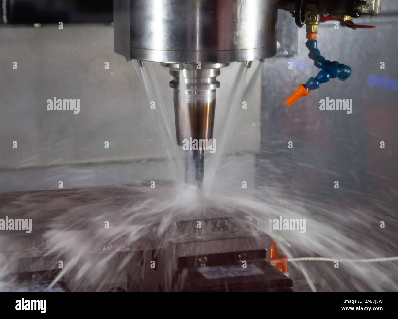 CNC milling machine cutting workpiece with coolant Stock Photo