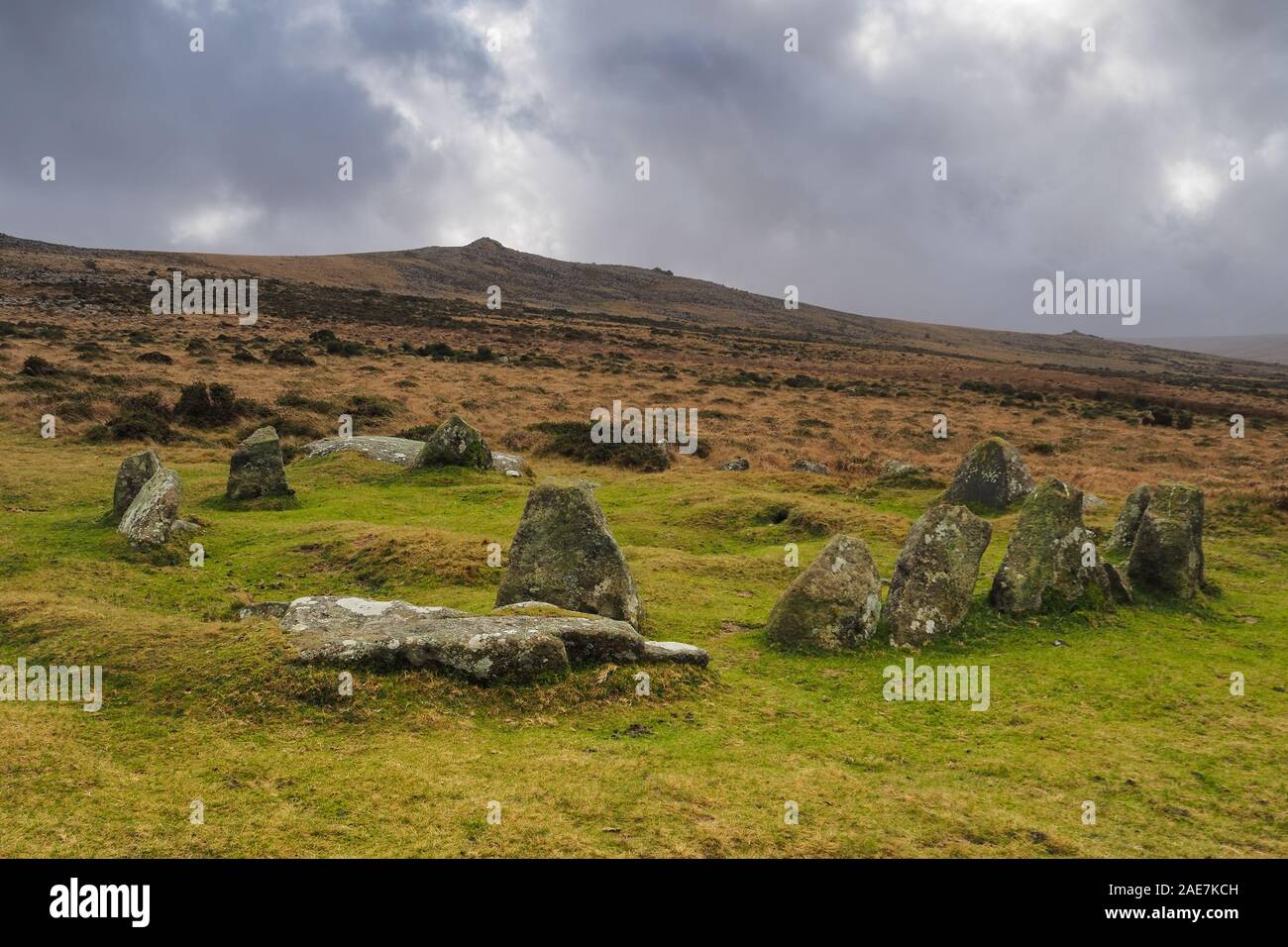 Nine Maidens Bronze Age cairn circle under Belstone Tor and stormy sky, Dartmoor National Park, Devon Stock Photo