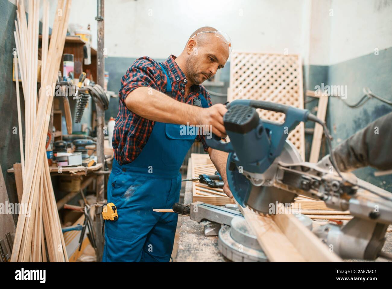 Carpenter works on circular saw, woodworking Stock Photo