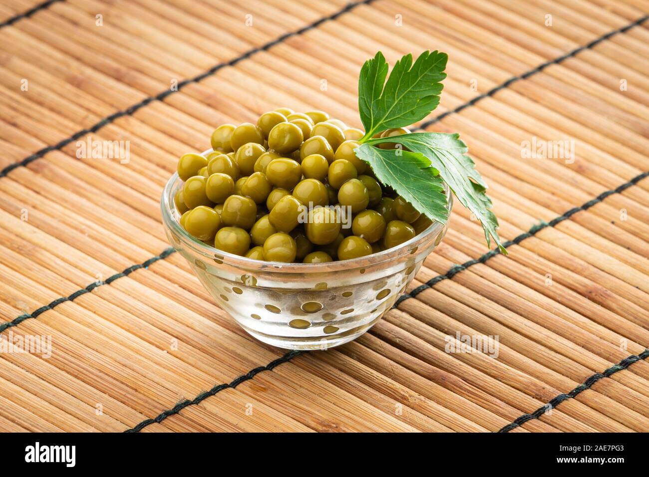 Canned green peas in the bowl on wood background Stock Photo
