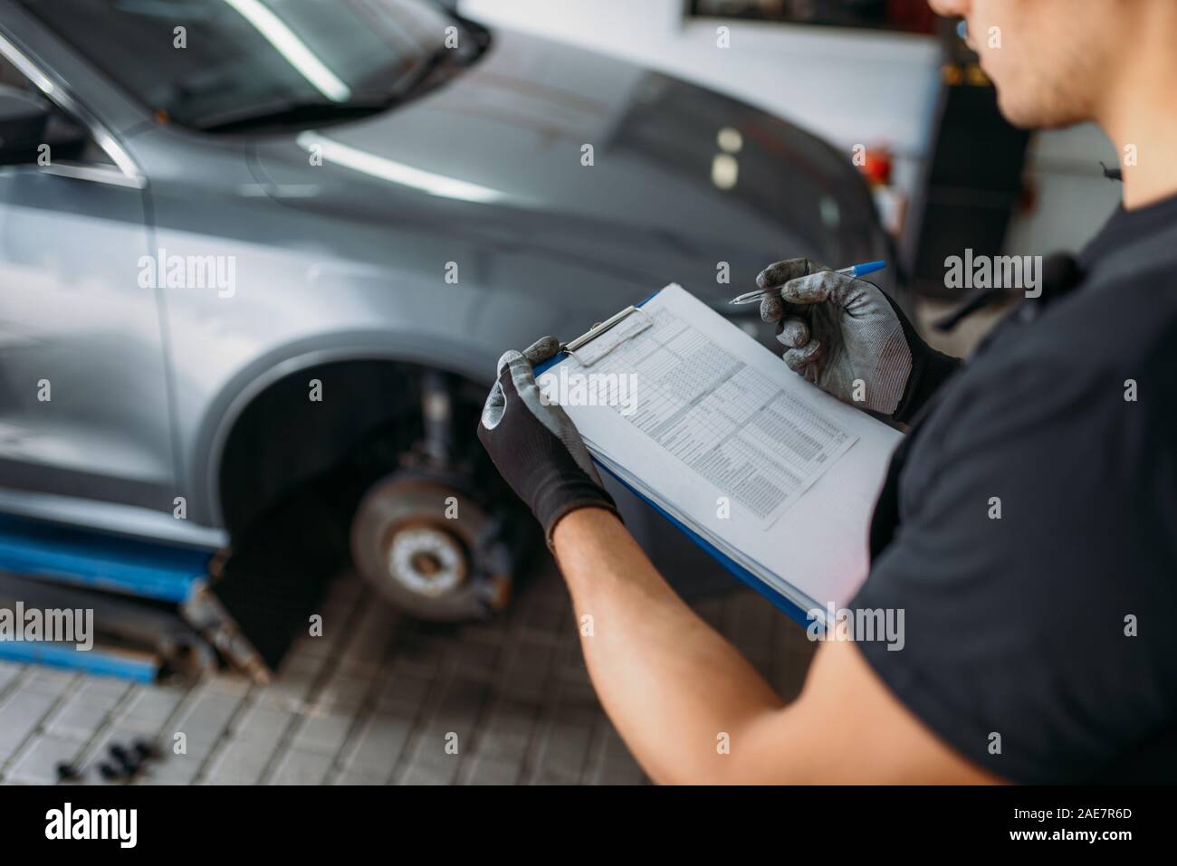 Mechanic holds inspection report, tire service Stock Photo Alamy