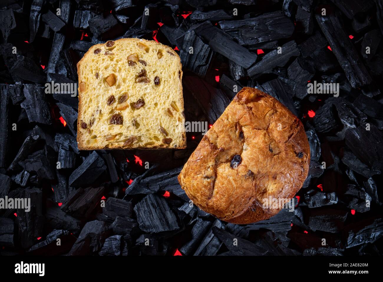 Sliced panettone placed on black charcoal background illuminated below with red light Stock Photo