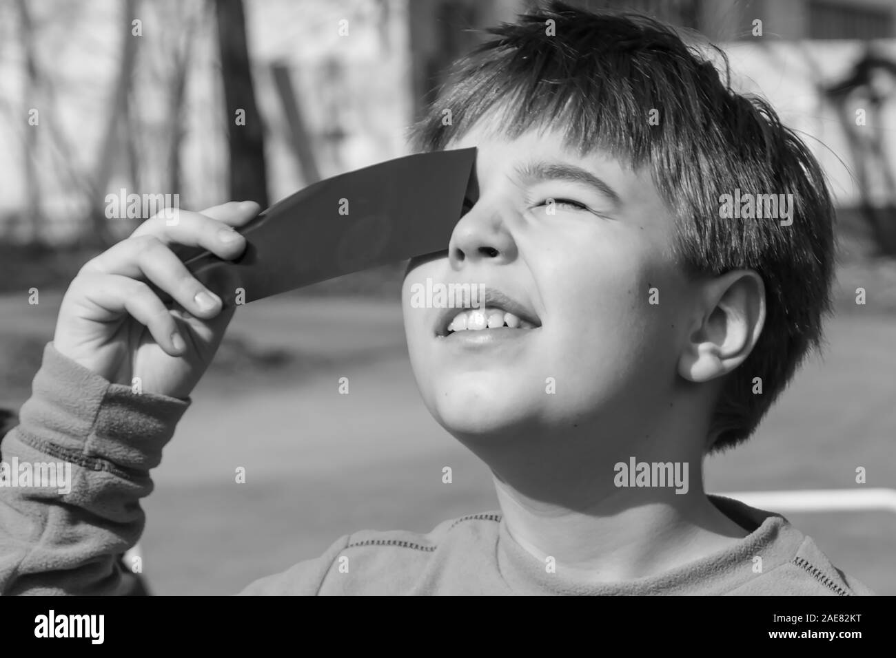 Boys watching a solar eclipse through a dark glass. Poland. Stock Photo