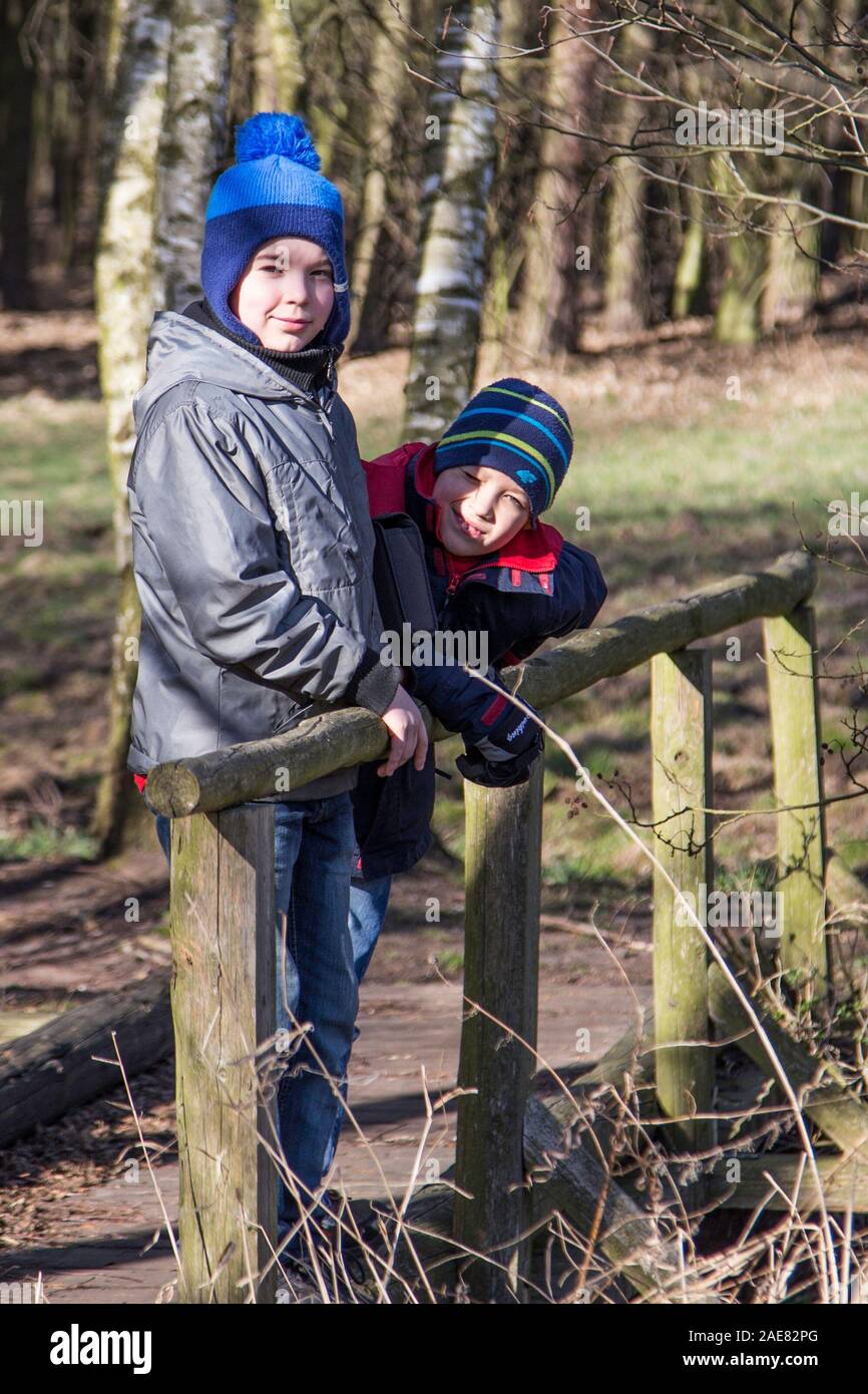 Two boys on a bridge over a river in the woods, winter Stock Photo - Alamy