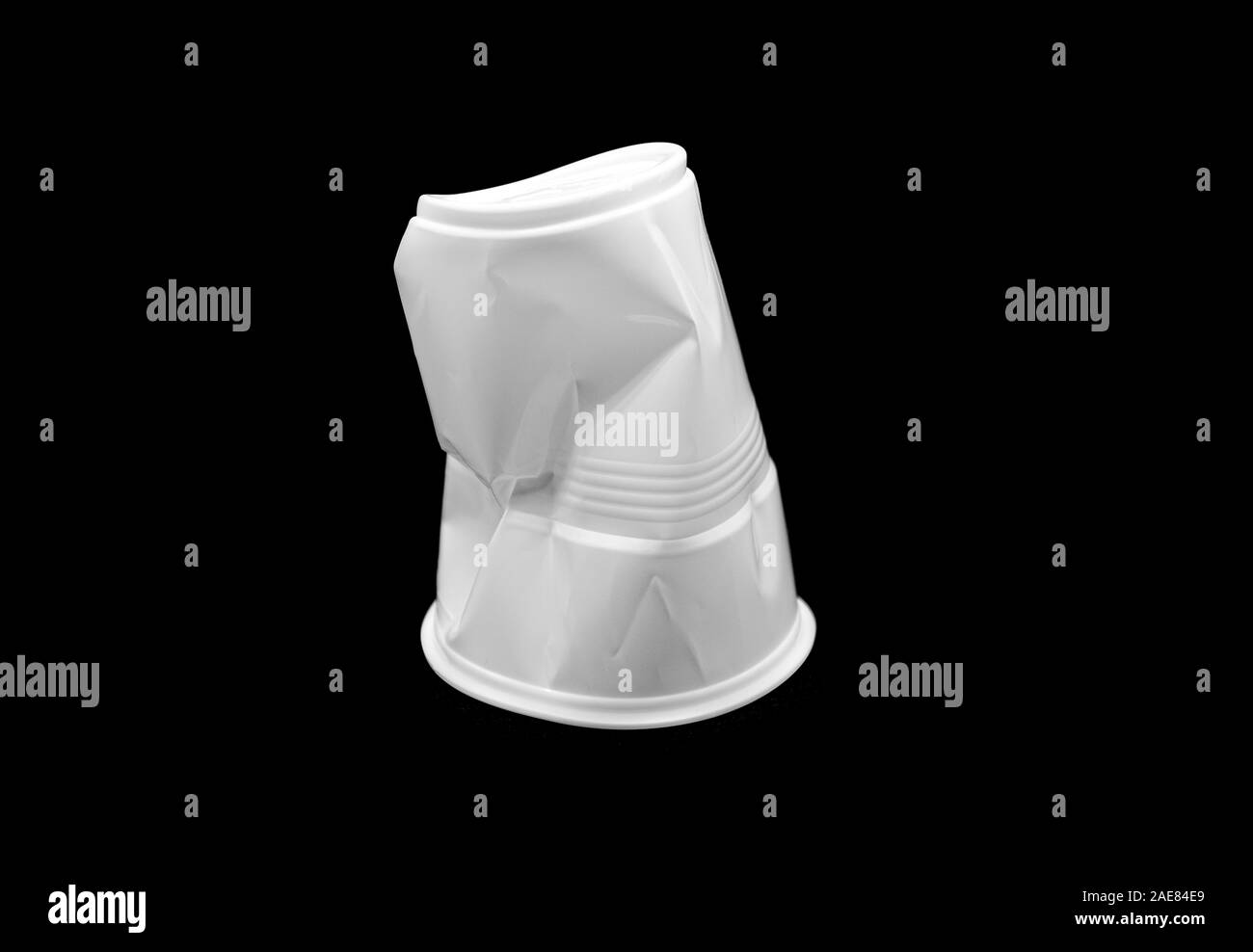 Crumpled plastic white Cup isolated on black Background Stock Photo