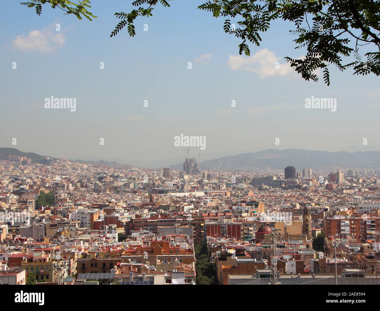 Barcelona Spain City Summer View with Sagrada Familia in Background. Smog is hiding the mountains. Stock Photo