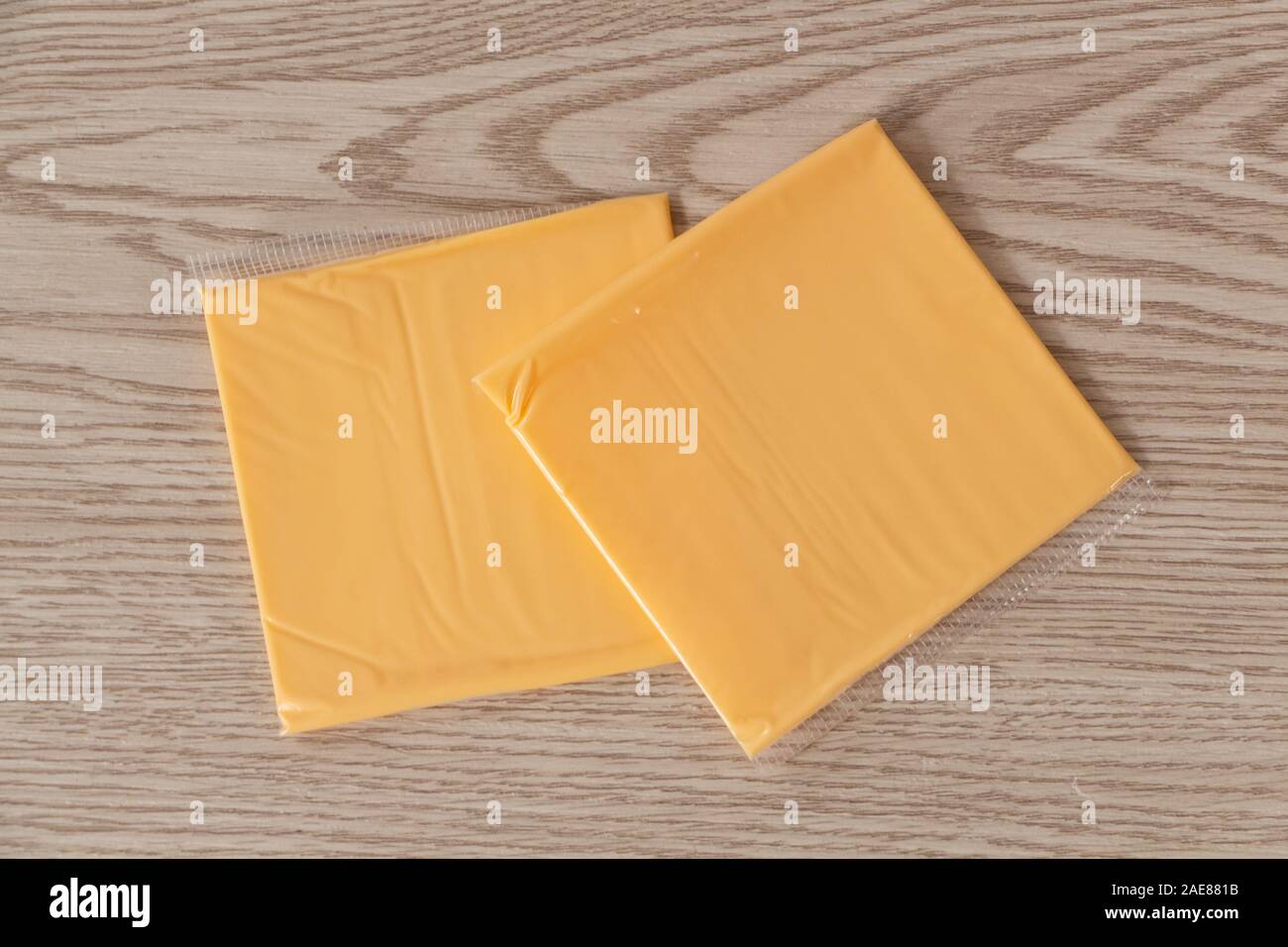 https://c8.alamy.com/comp/2AE881B/two-portions-of-processed-cheese-with-cheddar-in-plastic-packaging-2AE881B.jpg