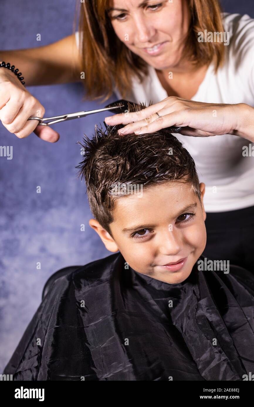 Beautiful boy getting a haircut with scissors Stock Photo Alamy