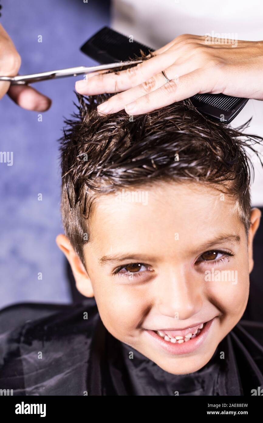 Beautiful Boy Getting A Haircut With Scissors Stock Photo