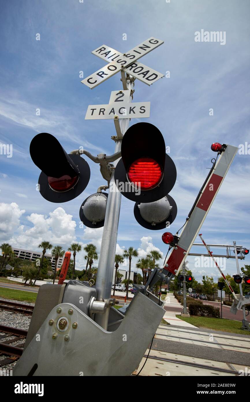 barriers and red light at train railroad level crossing near lakefront park kissimmee florida usa Stock Photo