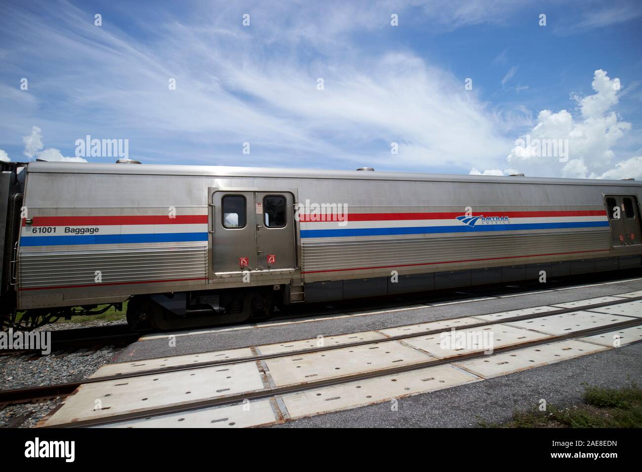 amtrack baggage car on train crossing road at train railroad level crossing near lakefront park