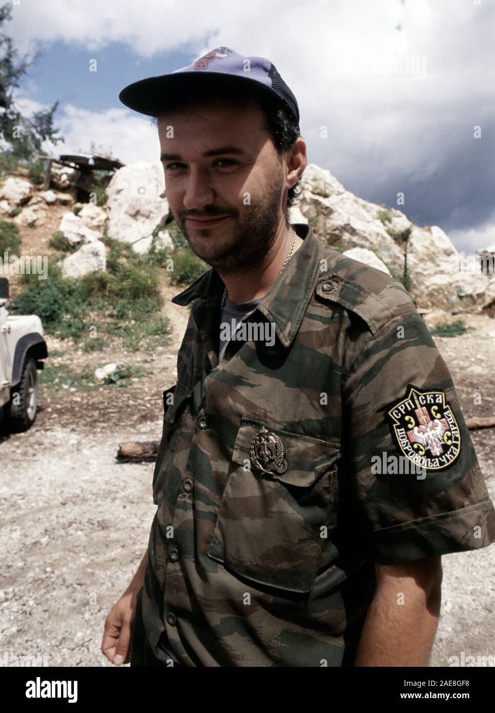 11th August 1993 During the Siege of Sarajevo: a Bosnian-Serb soldier outside his bunker on Mount Trebevic, above Sarajevo. He wears the shoulder patch of the Serb Volunteer Guard (Srpska dobrovoljačka garda or SDG), also known as Arkan’s Tigers, and the badge of the Serbian Army of Krajina. Stock Photo