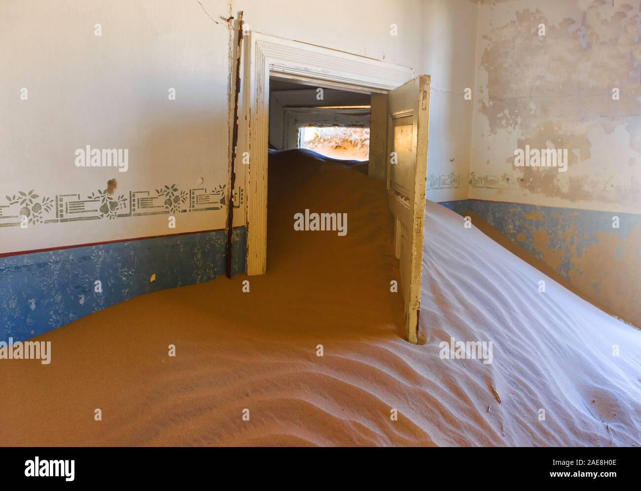 Abandoned and forgotten building and room being taken over by encroaching sandstorm, Kolmanskop ghost town, Namib Desert Stock Photo
