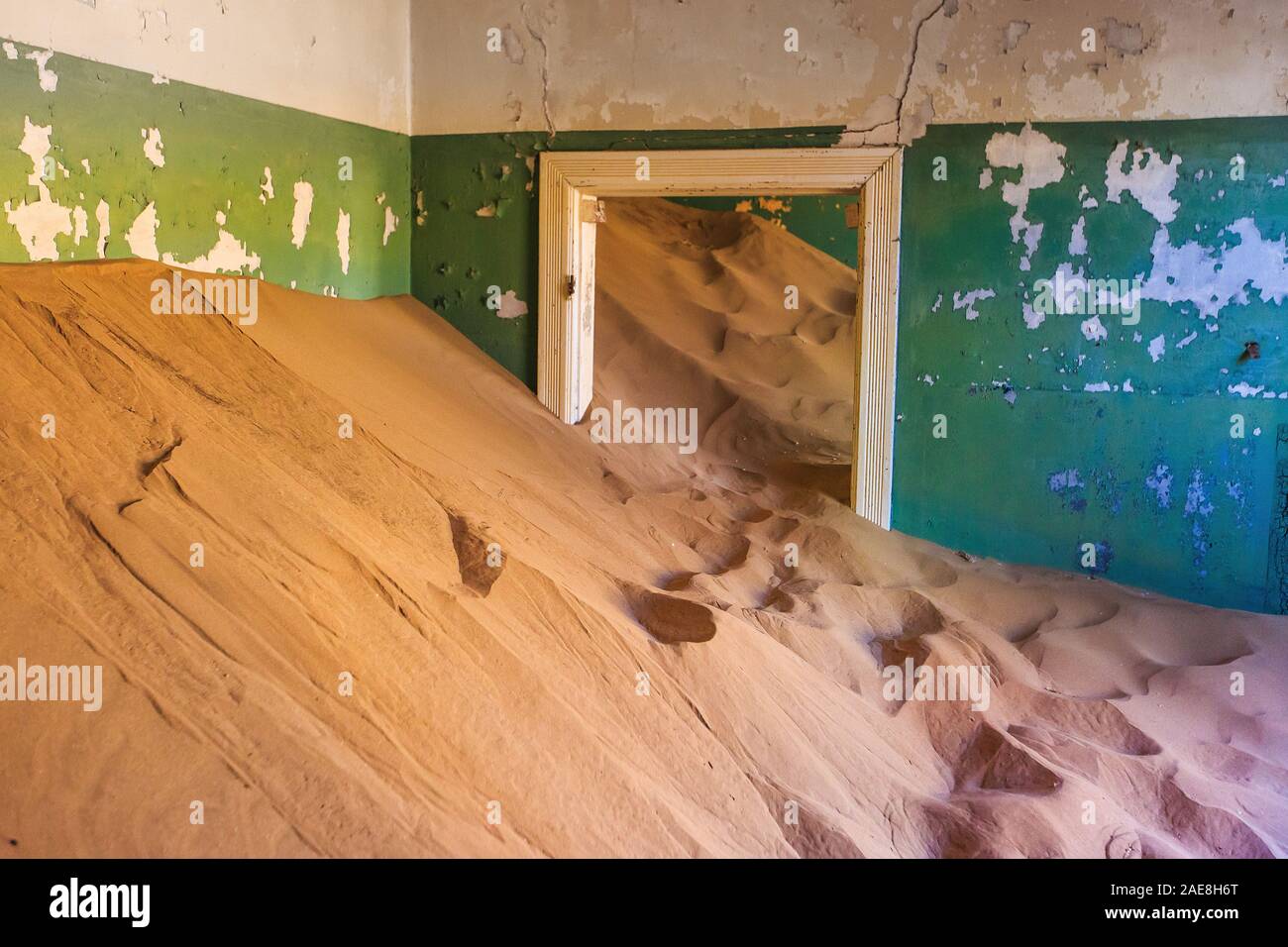 Abandoned and forgotten building and room being taken over by encroaching sandstorm, Kolmanskop ghost town, Namib Desert Stock Photo