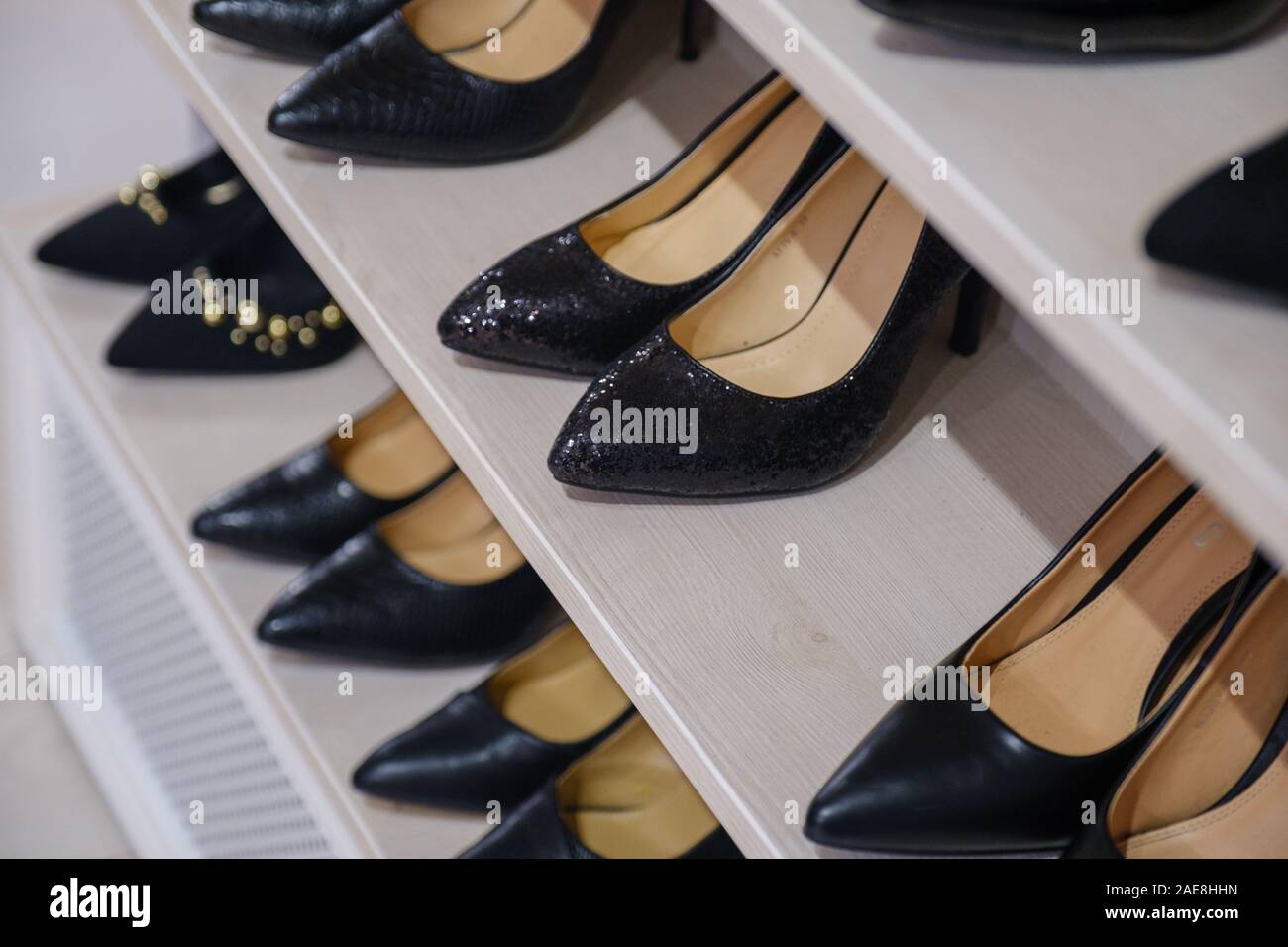 Side view of shelves of a shoe store with women's shoes on sale. Rows of new shoes in a store. Stock Photo