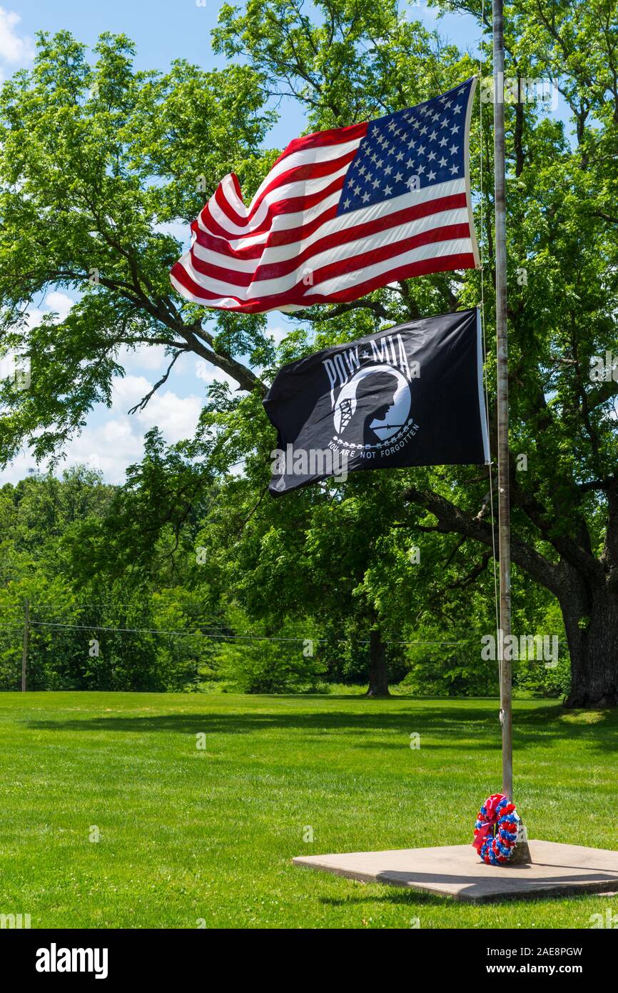 The American Flag and POW / MIA Flag flies in the wind at a cemetery over Memorial weekend in Humansville, Missouri. Stock Photo