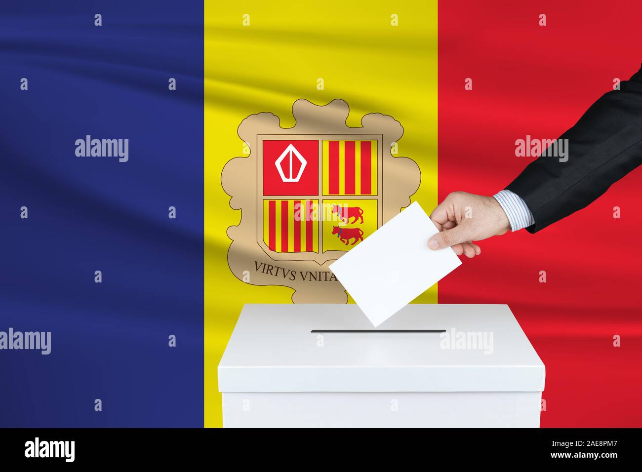 Election in Andorra. The hand of man putting his vote in the ballot box. Waved Andorra flag on background. Stock Photo