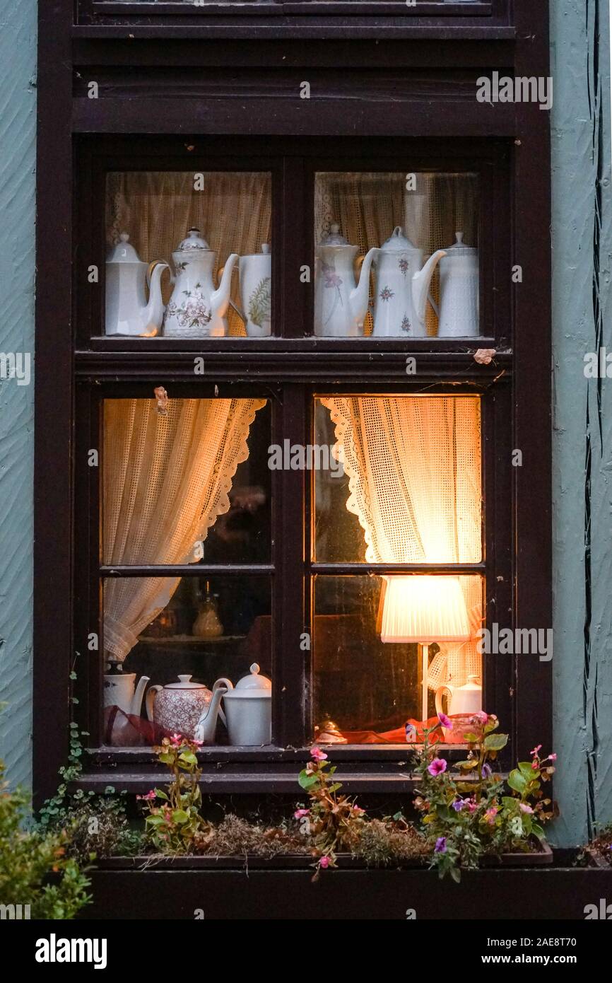Warmly lit window in a dark wintry lane Stock Photo