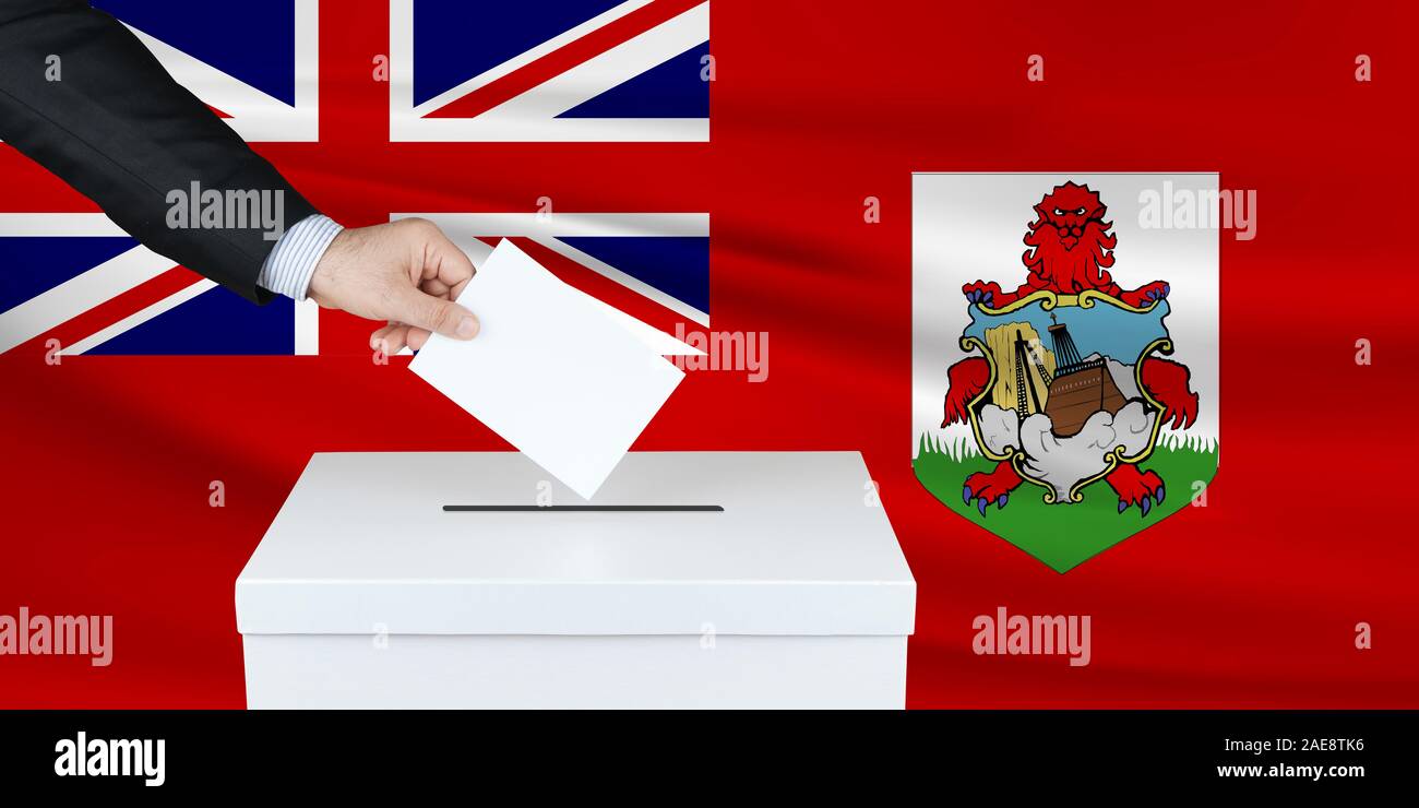 Election in Bermuda. The hand of man putting his vote in the ballot box. Waved Bermuda flag on background. Stock Photo