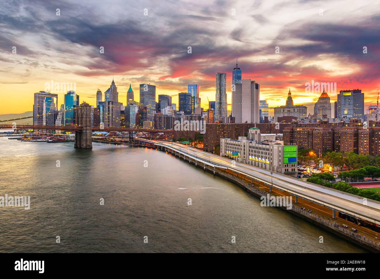 New York, New York, USA downtown Manhattan city skyline over the East River with the Brooklyn Bridge at dusk. Stock Photo