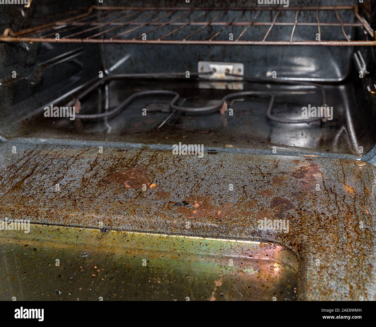 View inside filthy dirty electric oven with burnt grease and food on