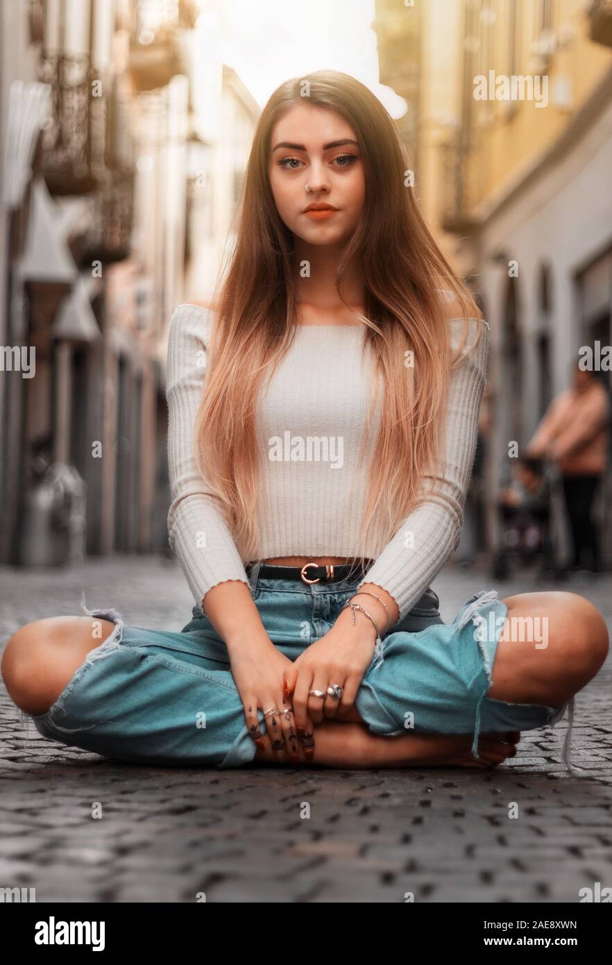 girl sitting on the ground in the street Stock Photo - Alamy
