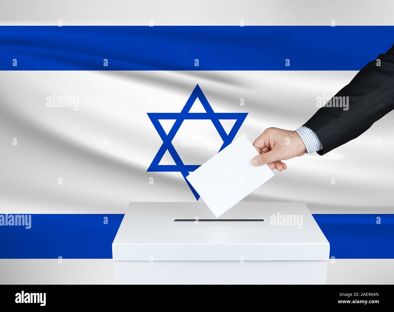 Election in Israel. The hand of man putting his vote in the ballot box. Waved Israel flag on background. Stock Photo
