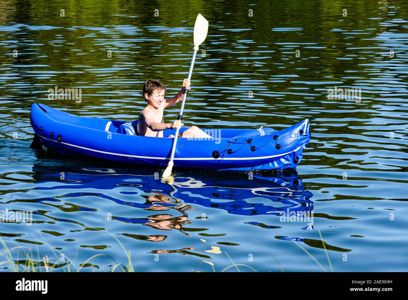 Boy, 12 years, paddling in a rubber boat on the Silbersee bathing lake, Celle, Lower Saxony, Germany Stock Photo