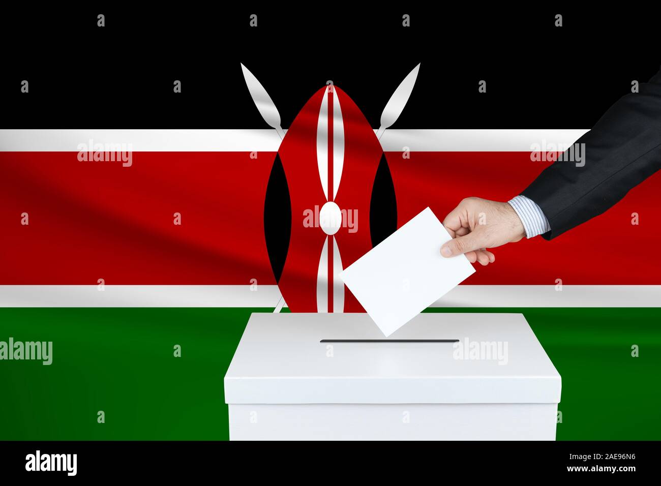 Election in Kenya. The hand of man putting his vote in the ballot box. Waved Kenya flag on background. Stock Photo