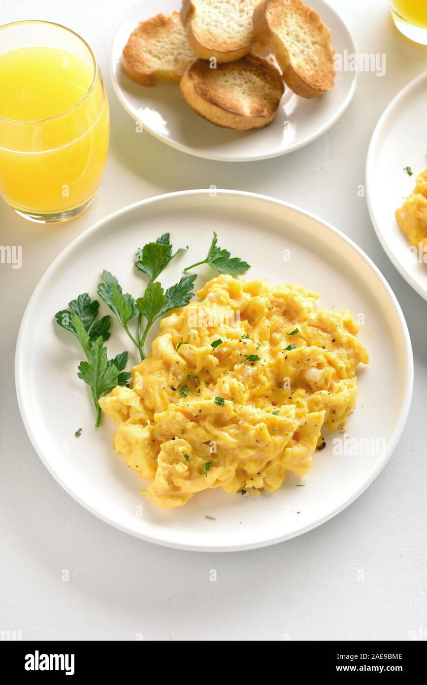 Scrambled eggs on plate over white stone background. Stock Photo