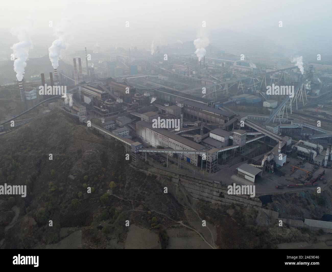 Aerial view of big factory in China. Air pollution by smoke coming out of chimneys. Coal Fossil Fuel Power Plant Smokestacks Emit Carbon Dioxide Pollution. Chengde, China. December, 12th, 2019 Stock Photo