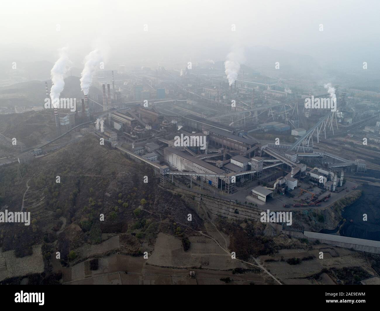 Aerial view of big factory in China. Air pollution by smoke coming out of chimneys. Coal Fossil Fuel Power Plant Smokestacks Emit Carbon Dioxide Pollution. Chengde, China. December, 12th, 2019 Stock Photo
